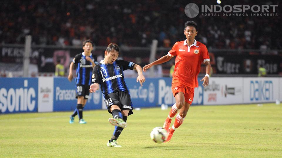 Hiroyuki Abe dari Gamba Osaka memberikan bola silang kepada rekan setimnya.
